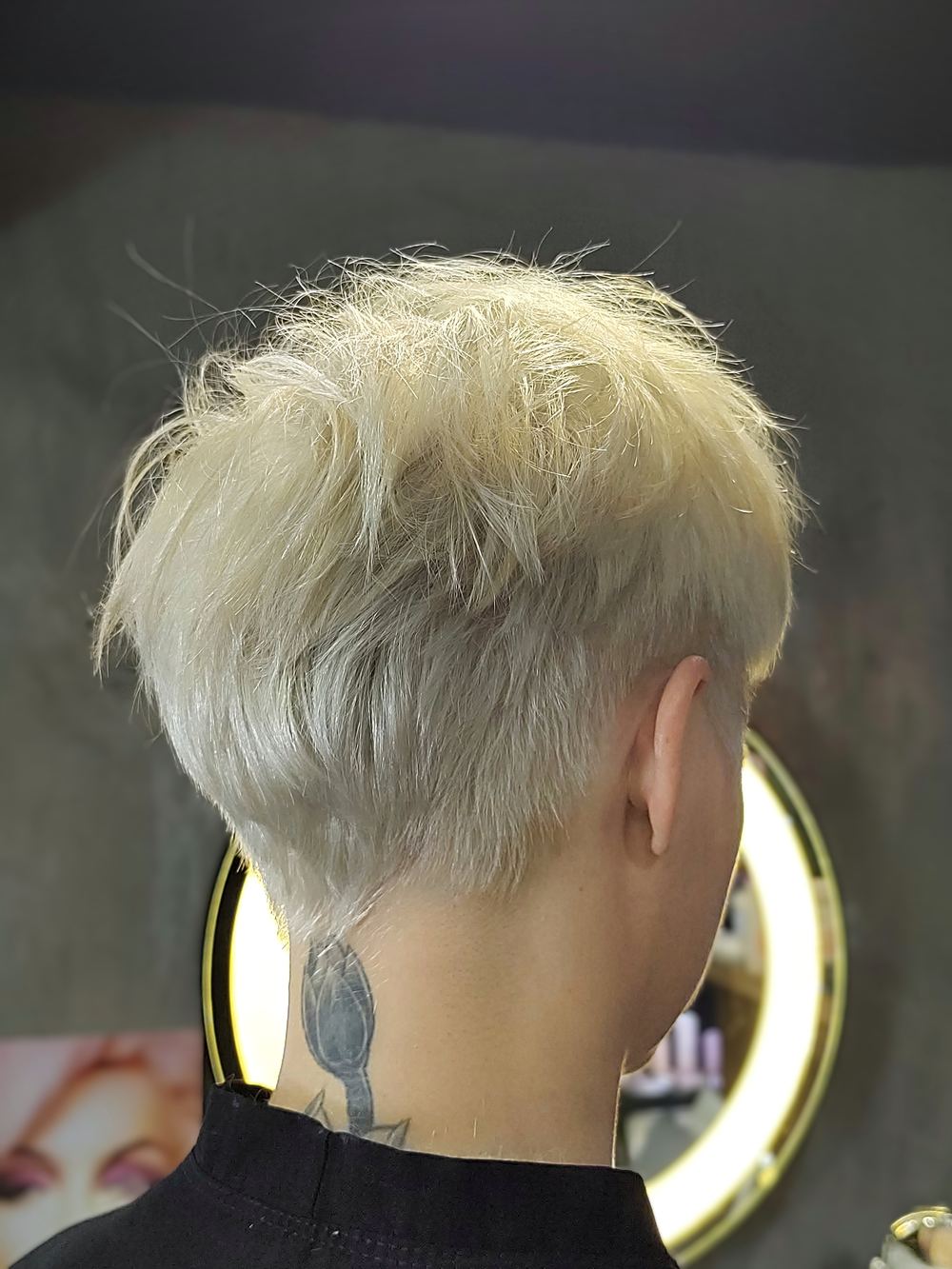 Vista posterior de corte pixie loiro platinado, mostrando a graduação da nuca
